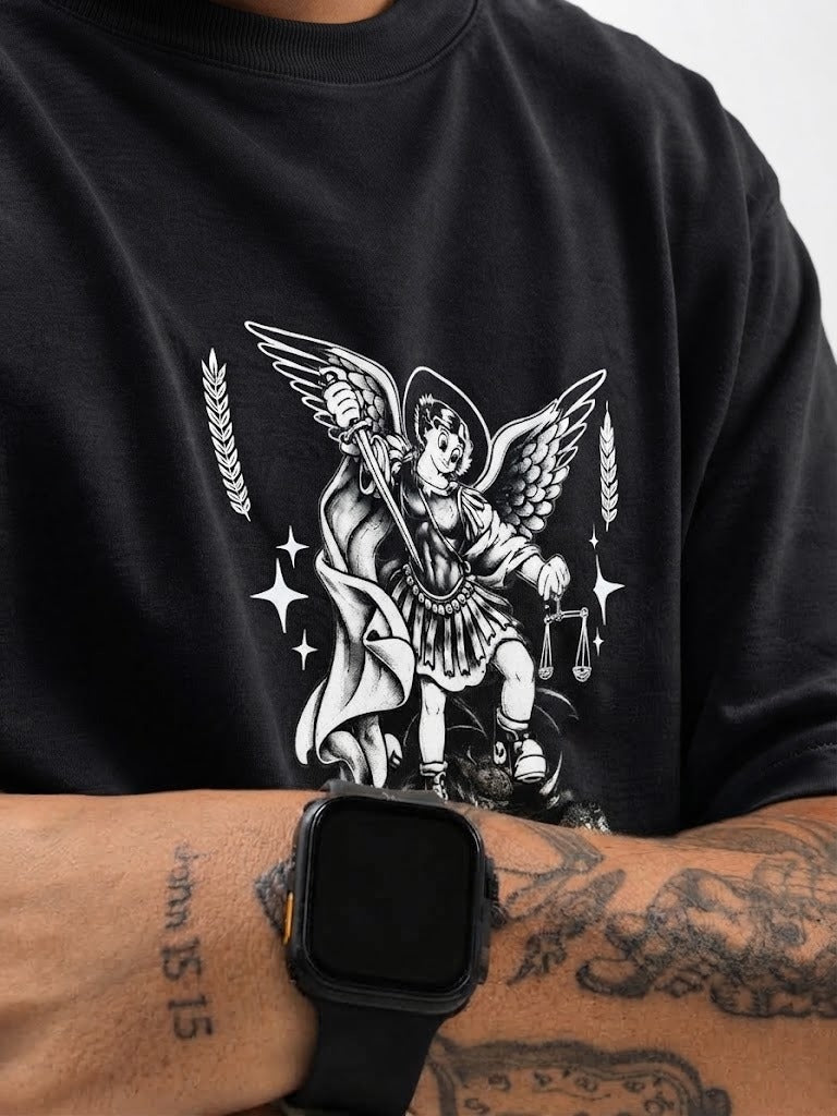 Detalhe da estampa de São Miguel Arcanjo na camisa preta